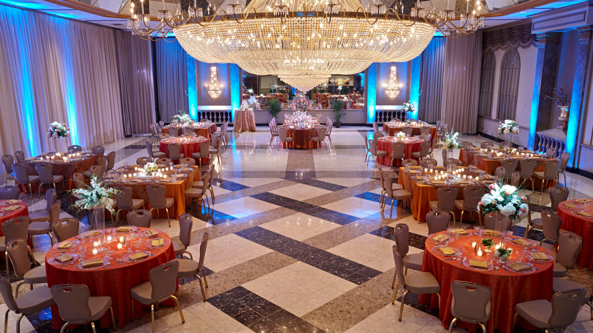 Beautiful event decorations featuring estate tables and blue uplighting at Martin's Crosswinds.